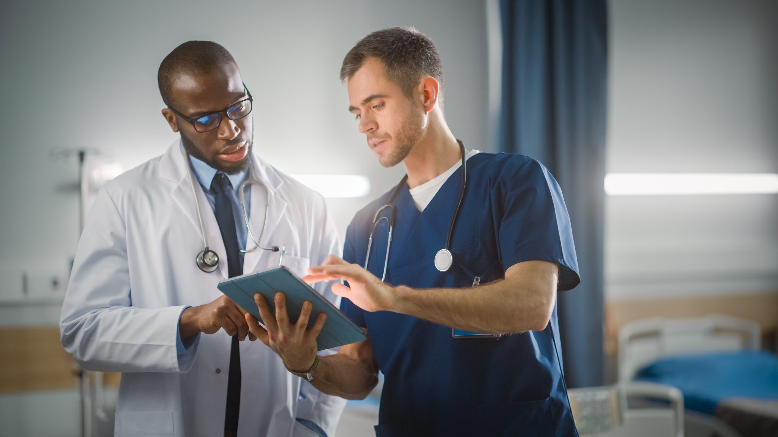 Staff members communicating regarding a patient chart via tablet.