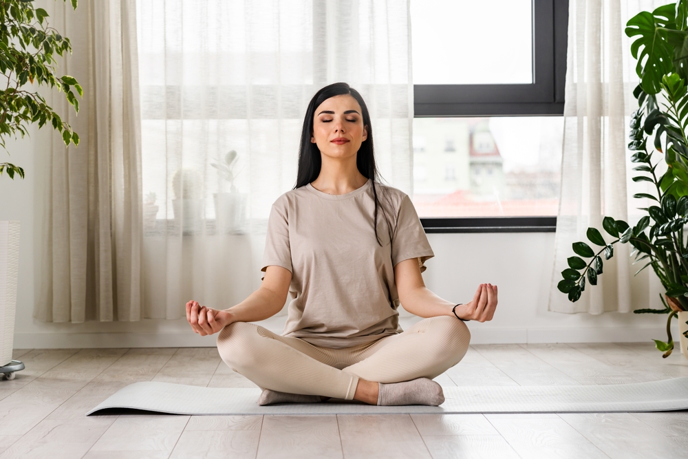 Woman meditating to focus on mental wellness.